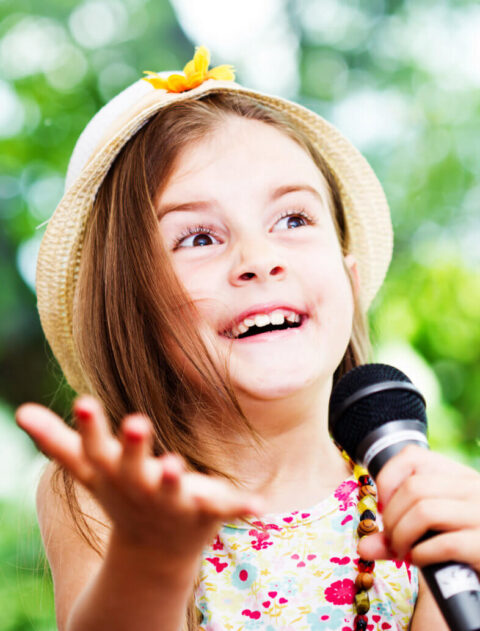 pretty little girl with the microphone in her hands - outdoor